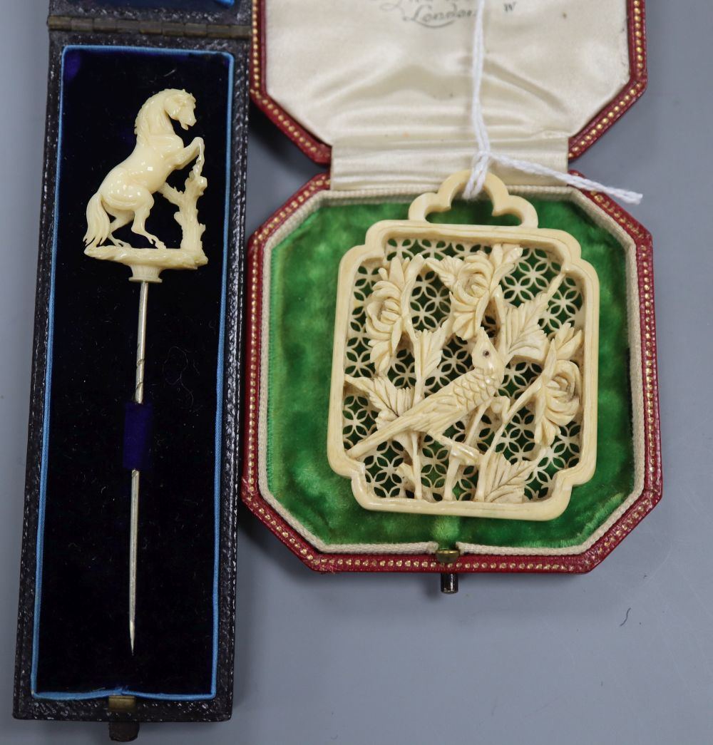 A carved ivory rearing horse stick pin and a carved ivory panel pendant? 55mm.